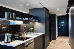 a kitchen with a counter and a blue wall at The Capital 15 on Orange Hotel & Spa in Cape Town