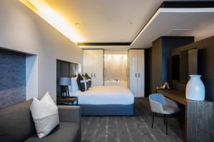 a hotel room with a bed and a couch at The Capital 15 on Orange Hotel & Spa in Cape Town