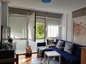 a living room with a blue couch and windows at APARTAMENTO VALMAYOR in Potes