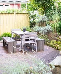 a patio with a table and benches in a garden at Hideaway Extertal in Extertal