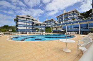 una piscina di fronte a un edificio di Agua Azul, Condomínio com Ótima infraestrutura a uma quadra da Praia Brava N396 a Florianópolis