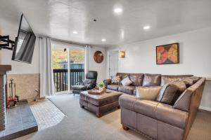 a living room with a leather couch and a chair at 2BD 2BA Condo with Hot Tub and Pool in Park City