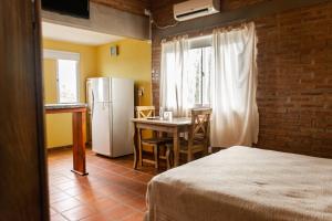 uma cozinha com uma mesa e um frigorífico num quarto em Rio De Arena em Nono