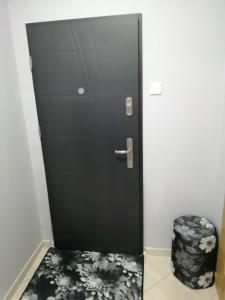Czarne drzwi ze stołkiem przed nimi w obiekcie Apartament dla turystów w Tychach