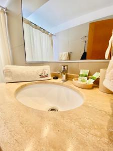 a bathroom with a sink with a large mirror at Apartamento Alma Capital in Iquique