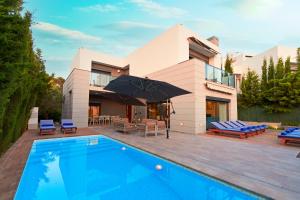 a villa with a swimming pool in front of a house at Casa Lui in Ibiza Town