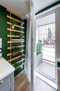 a kitchen with green walls and a sliding door with plants at Flora Apartment Kosice Center in Košice