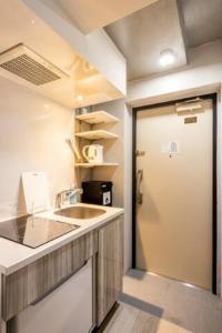 una cocina con fregadero y una puerta a una habitación en Marvelous Ryogoku - Vacation STAY 74211v, en Tokio