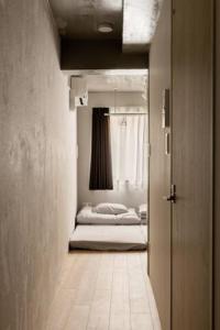 un pasillo con 2 camas en una habitación con puerta en Marvelous Ryogoku - Vacation STAY 74211v, en Tokio