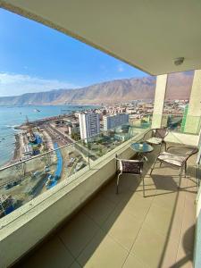 a balcony with chairs and a view of the ocean at Apartamento Alma Capital in Iquique