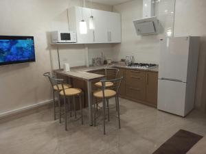 a kitchen with a refrigerator and a table and chairs at Marko de Luxe in Ivano-Frankivsk