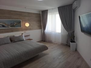 um quarto com uma cama e uma grande janela em Marko de Luxe em Ivano-Frankivsʼk