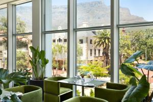 a room with a table and chairs and a large window at The Capital 15 on Orange Hotel & Spa in Cape Town