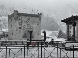a building with a clock on it in the snow at APARTAMENTO VALMAYOR in Potes