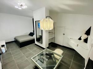 a living room with a glass table and a couch at Suite Apollon - Centre-ville in Saint-Étienne