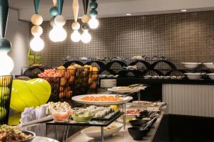 a buffet line with many plates of food on display at The Capital 15 on Orange Hotel & Spa in Cape Town