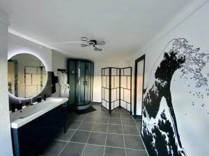La salle de bains est pourvue d'un lavabo et d'un miroir. dans l'établissement Suite Apollon - Centre-ville, à Saint-Étienne
