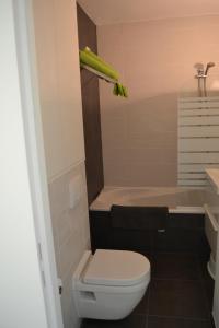 a bathroom with a toilet and a sink and a tub at Studio 24 Oostende in Ostend