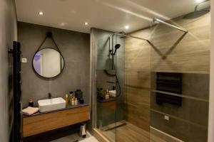 La salle de bains est pourvue d'une douche, d'un lavabo et d'un miroir. dans l'établissement MAISON AVEC SPA PRIVATIF ( JACUZZI ET SAUNA), à Bailleval