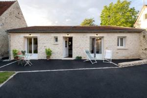 a house with chairs in front of it at MAISON AVEC SPA PRIVATIF ( JACUZZI ET SAUNA) in Bailleval