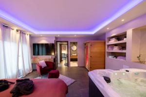 a bedroom with a bath tub and a room with at MAISON AVEC SPA PRIVATIF ( JACUZZI ET SAUNA) in Bailleval