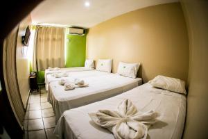Dos camas en una habitación con toallas. en Cidade Verde Flat Hotel, en João Pessoa