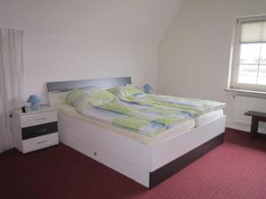 um quarto com uma cama branca e uma mesa de cabeceira em Jägerlehrhof, Breiholz em Breiholz