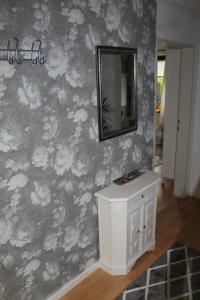 een badkamer met een spiegel en een witte kast bij Ferienhaus Im Winkel in Krummhörn