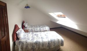 a bedroom with two beds and a sloped ceiling at White Hill Country House B&B in Castleblayney