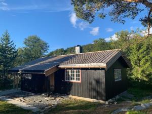a black shed with a gambrel roof at Charming Mountain Cabin in Oppdal