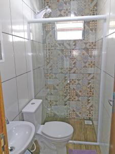 a bathroom with a toilet and a sink at Recanto da Madre in Guarda do Embaú