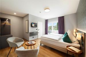 a hotel room with a bed and a table and chairs at Landgasthof Kranz in Ohlsbach