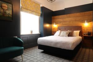 um quarto com uma cama, uma cadeira e uma janela em The Craft House em Plymouth