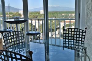 uma mesa de vidro e cadeiras numa varanda com vista em Le Belvédère - T2 en front de mer em Argelès-sur-Mer