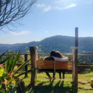 une femme posant sur un banc avec un cheval dans l'établissement Aconchego no Campo, à São Roque