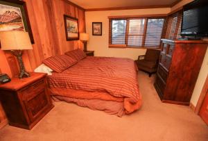 a bedroom with a bed and a dresser and a television at Mountainback #52, Loft, Corner in Mammoth Lakes