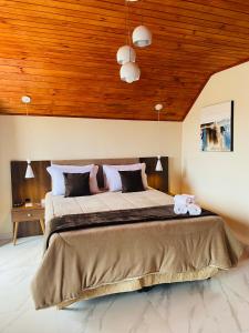 a bedroom with a large bed with a wooden ceiling at Pousada Villarejo in Monte Verde