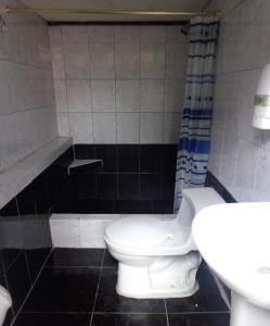 a bathroom with a toilet and a sink at Hostal Yumbo Imperial in Quito