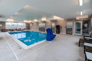a large swimming pool in a large building at Avid Hotel Cedar Rapids South - Arpt Area, an IHG Hotel in Cedar Rapids