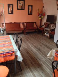 a room with a table and chairs and a piano at Hostal Yumbo Imperial in Quito