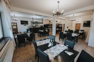 a restaurant with tables and chairs and a dining room at Pensiunea Rau Sadului in Rau Sadului