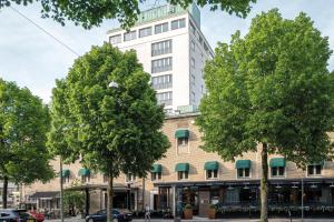 ein hohes weißes Gebäude mit Bäumen davor in der Unterkunft Elite Park Avenue Hotel in Göteborg