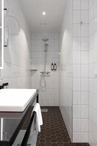 ein weißes Badezimmer mit Dusche und Waschbecken in der Unterkunft Elite Park Avenue Hotel in Göteborg