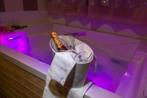 una vasca da bagno con una bottiglia di champagne in un asciugamano di Hotel Sirio a Boscotrecase