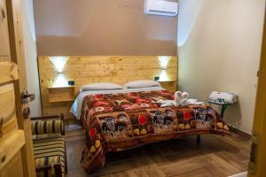 Schlafzimmer mit einem Bett mit einem Kopfteil aus Holz in der Unterkunft Hotel Sirio in Boscotrecase