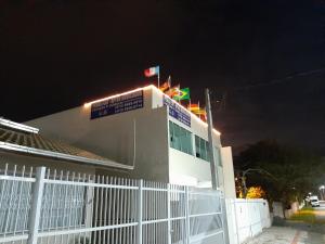 佩尼亚PENHAFLAT, STUDIO COMPLÉTO, C GARAGEM , A 700 m do parque e 120 m da praia的一栋前面有白色围栏的建筑