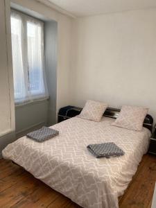 a bedroom with a bed with two pillows on it at Appart au 1 etage in Saint-Rémy-sur-Durolle