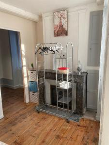 a room with a fireplace and a metal shelf at Appart au 1 etage in Saint-Rémy-sur-Durolle