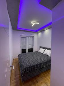 um quarto com uma cama com um tecto roxo em Trebinje LUX Apartman sa garažom blizu centra em Trebinje