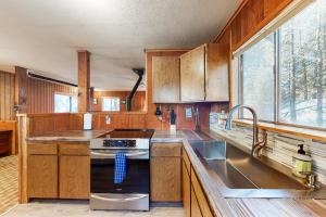 uma cozinha com armários de madeira e um lavatório em Rustic Mountain Retreat em Soda Springs